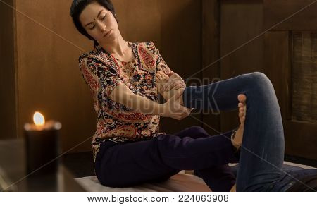 Professional therapist giving traditional Thai massage or Thai yoga massage treatment.