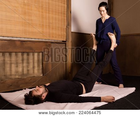 Foot massage in thai studio. Professional therapist giving traditional Thai massage.