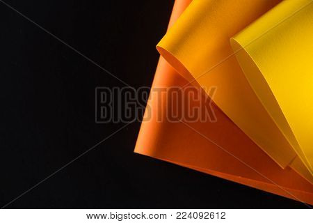 orange and yellow colored papers isolated on black