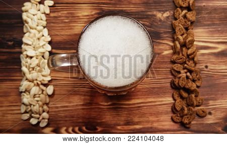 Beer light in a mug and a different dry salty snack