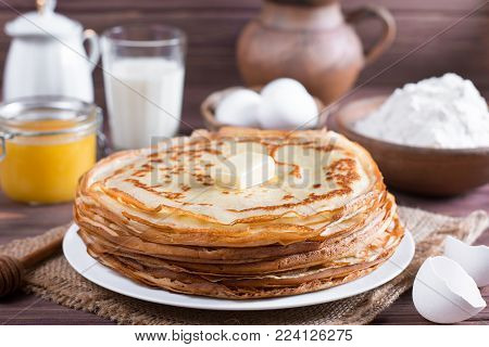 Many pancakes on a wooden background. Traditional Ukrainian or Russian pancakes. Shrovetide Maslenitsa. Traditional dishes on the holiday Carnival Maslenitsa Shrovetide.