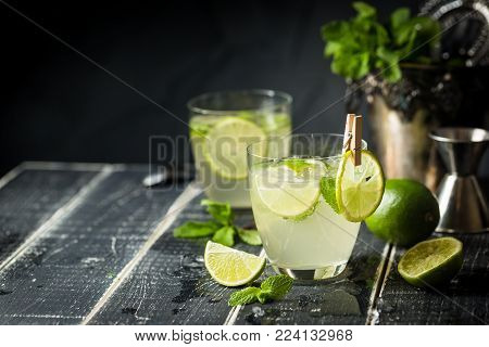 Lemonade or mojito cocktail with lemon and mint, cold refreshing drink or beverage with ice