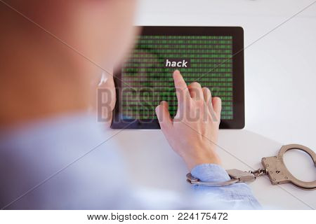 Woman hands in handcuffs with tablet. Hack concept.
