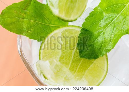 Slices Of Lime With Ice On Wooden Table