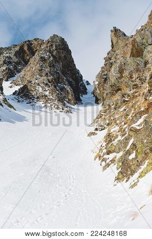 Close-up. View of a snowy couloir between sharp rocks. A place for skiing freeride and backcountry. North Caucasus. Russia