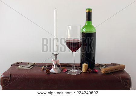 Still life with a  bottle of wine on an old suitcase