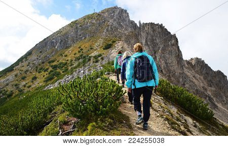 Tourists on a trip in Dolomites mountain , Val di Fiemme, South Tyrol, Italy.