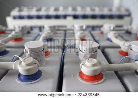 Electric DC battery. Industrial accumulators connected plus to minus. Direct current supply.