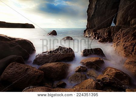 Pembrokeshire coastline with crashing seas falling upon rocks.