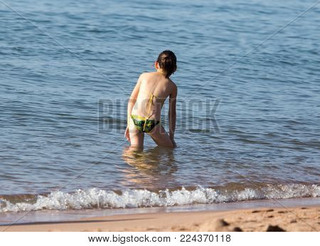 little girl in a bathing suit on the beach .
