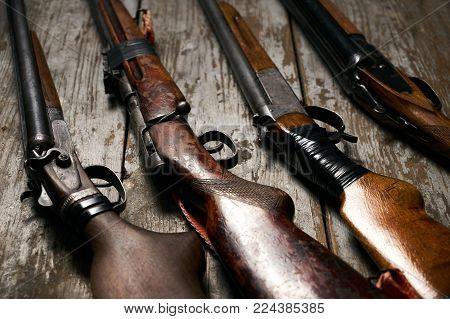 ollection of hunting rifles. Rifles, shotguns on wooden table background, Hunting guns close-up