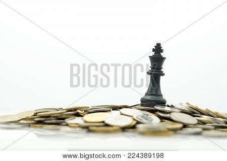 A King Chess is placed on a pile of coins.using as background business concept and Strategy concept with copy space for your text or design.
