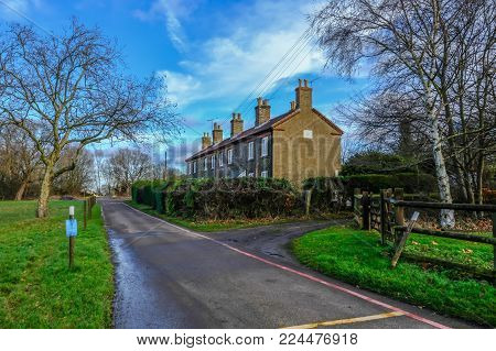Hainault Forest, Essex, England, UK  - December 26, 2017: Row of cottages in Epping Forest, used for rangers, taken on a bright blue sky day.
