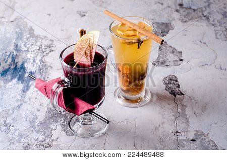 Hot grog, mulled red wine with lemon, cinnamom stick and honey on a gray background, selective focus. Fruit drink with tea, rome, anise and other spices. Food and drink concept, view from above.