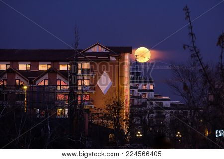 Bucharest, ROMANIA - January 31 2018: Super Blue Blood Moon rising close to Hotel Caro in Bucharest. Rare lunar trifecta. BUCHAREST January 31 2018
