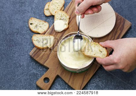 french vacherin mont d'or, soft cheese with washed rind, scooping with a spoon