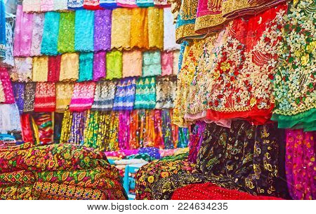 The wide range of bright colored fabrics, decorated with rhinestones, embroideries, lace, prints and lurex, Vakil Bazaar, Shiraz, Iran.