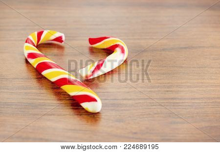 candy in the shape of heart on a wooden background for the celebration of Valentine's Day. Heart is broken. Cheating.