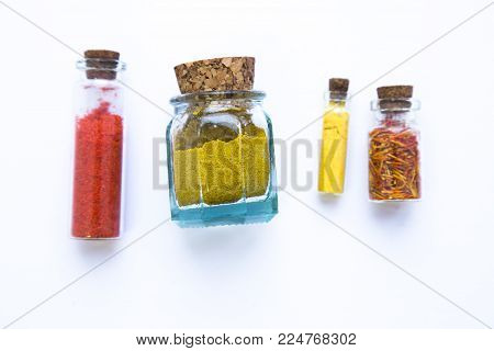 Set of spices and herbs in glass jars with corks isolated on white, copy space
