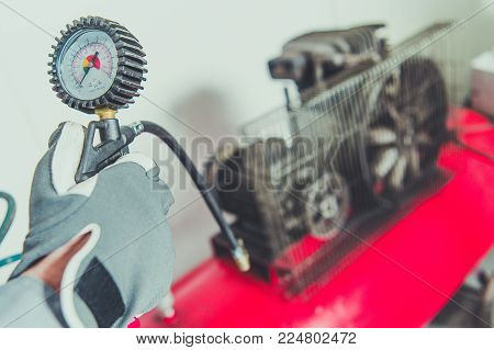 Worker Using Air Compressor Tool. PSI Meter Closeup. Air Pressure Generator Equipment.