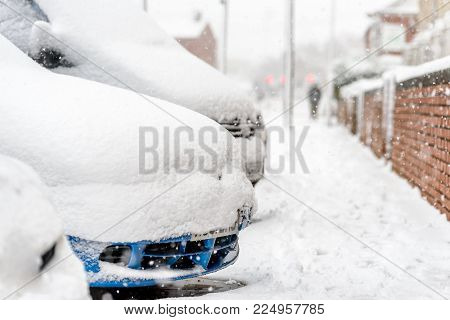 Day view parked cars under heavy snow in United Kingdom.