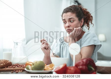 Curly Woman Sitting In Kitchen Having Allergy To Peanuts