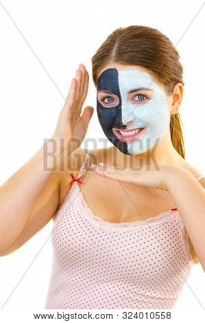 Woman With Clay Carbo Black Mask On Half Face And White Mud On Second Half. Girl Taking Care Of Oily