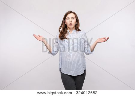 Brunette Woman Showing Puzzled Reaction.studio Portrait Of Brunette Woman In Casual Clothes Showing 
