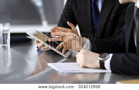 Businessman Using Tablet Computer And Work Together With His Colleague Or Partner At The Glass Desk 