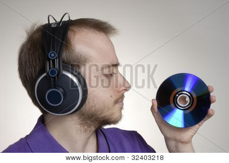 Junge Disk Jockey holding einen kompakte disc.young Mann mit Kopfhörer.