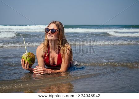 Sexy And Young Woman In A Stylish Bikini Swimsuit Holding A Coconut On The Ocean Tropical Paradise S