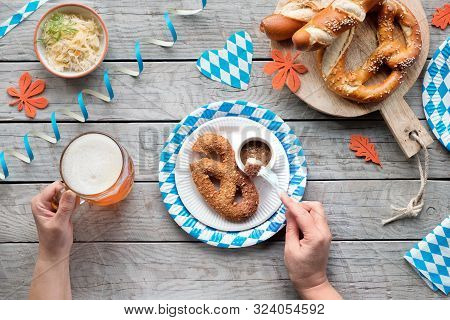 Oktoberfest Traditional Food And Beer. Hands Holding Beer Mug And Fork With White Sausage. Sauerkrau