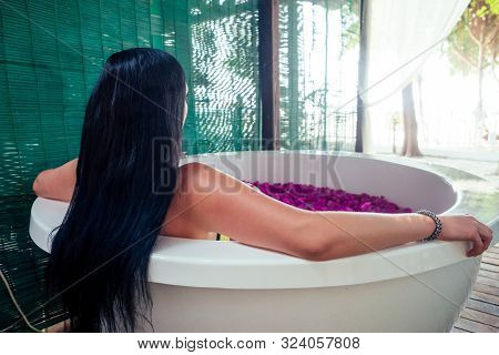 Woman Sexy Brunette Relaxing In Bath With Tropical Flowers Outdoor At Luxury Hotel Resort. Organic S