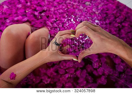 Hands Fingers In The Shape Of A Heart In Bath With Petals In Tropics