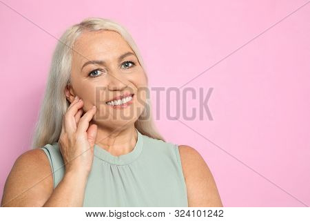 Portrait Of Mature Woman With Beautiful Face On Pink Background. Space For Text