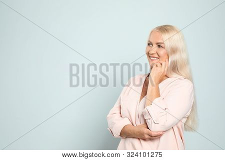 Portrait Of Mature Woman With Beautiful Face On Grey Background. Space For Text