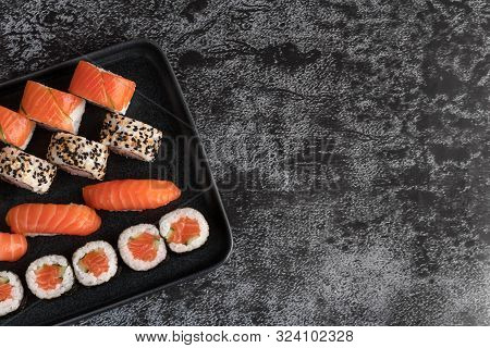 Sushi Set Of Nigiri And Maki Rolls Served On Stone Plate. Japanese Food. Top View With Copy Space