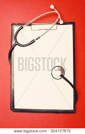 Polyclinic And Hospital. Medical Insurance. Phonendoscope And Paper Tablet On Red Background Copy Sp