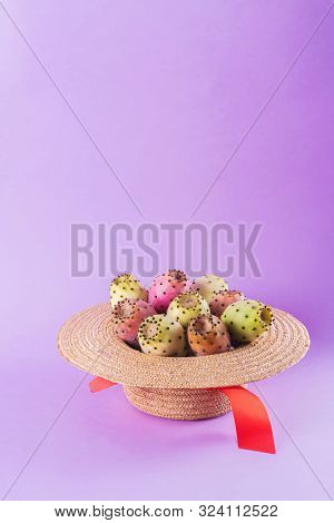 Opuntia Fruit In A Straw Hat On A Trendy Purple Background. Prickly Pear Or Fichi Dindia Salento, Pu