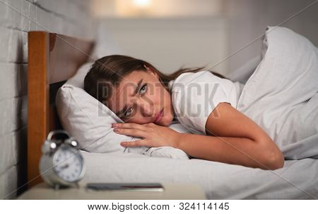 Insomnia. Unhappy Young Woman Suffering From Anxiety And Sleeplessness Lying In Bed At Home At Night