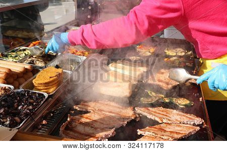 Cook With Blue Latex Glove For Hygiene While Cooking Sausages In A Street Food Stall