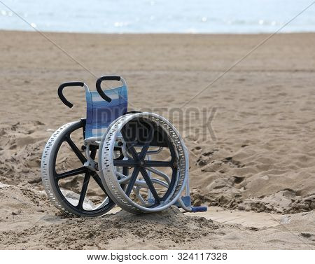 Wheelchair With Big Metal  Wheels On The Beach In Summer Without People