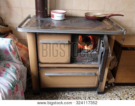 Ancient Wood-burning Stove With Burning Fire And Hot Pots