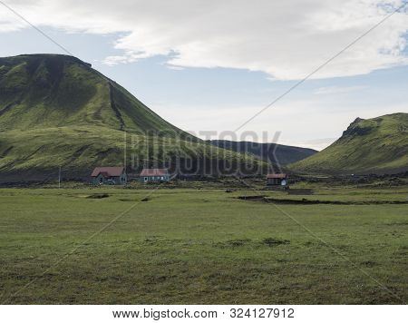 Hvanngil Campsite Path In Lava Field And Green Valley, Small Houses Of Hvanngil Hut. Volcanic Mounta