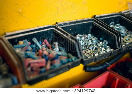 Metal, Plastic Screws, Nuts And Bolts On The Table In Car Mechanic Shop. Car Repair Equipment