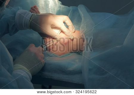 Surgeon Man Inputting Drug For Local Anesthesia Before Surgery In Patient Leg, Hands Closeup. Infilt