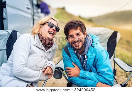 Young Couple Smiling With  Motorhome, Rv Or Campervan On Beach.