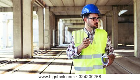 Male Architect Communicating On Walkie-talkie At Site