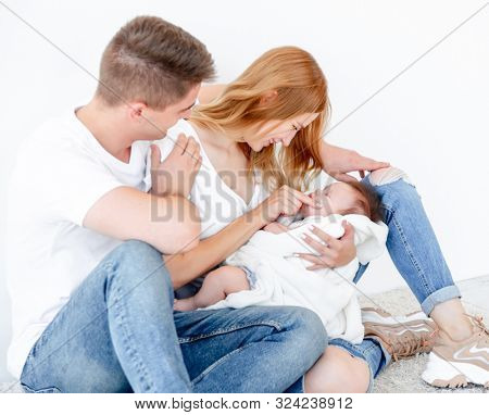 Father, mother and sleeping baby girl at home