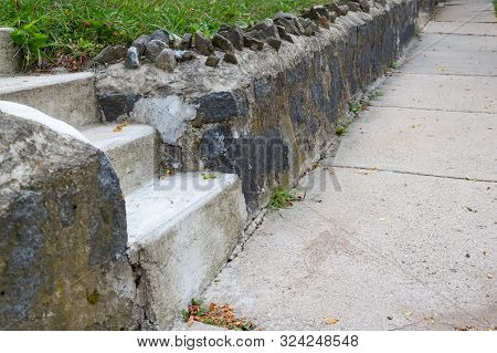 Concrete Sidewalk Beside A Rock Retaining Wall, Cement Stais, Horizontal Aspect